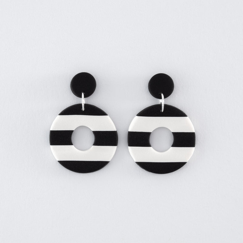 Black & White N°1 handmade dangle earrings – round, black and white striped earrings with 925 sterling silver findings on light grey background.