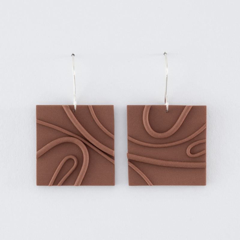 Mocha Mousse N°1 handmade dangle earrings – creamy brown square shapes with playful wavy textures and 925 sterling silver findings on light grey background.