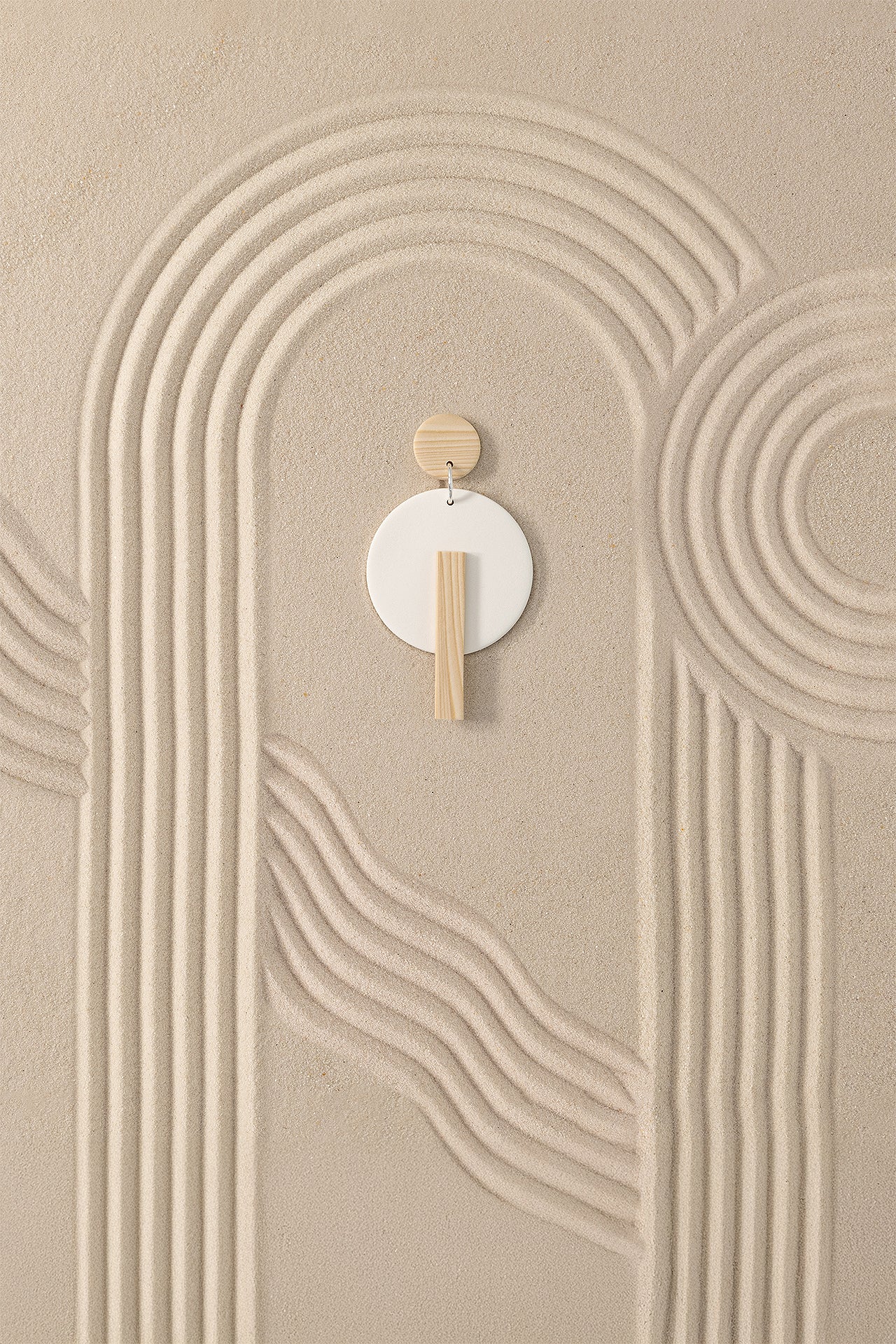Kyoto N°1 handmade dangle earring with 925 sterling silver findings from Portamira’s Kyoto collection on Zen garden sand textures.