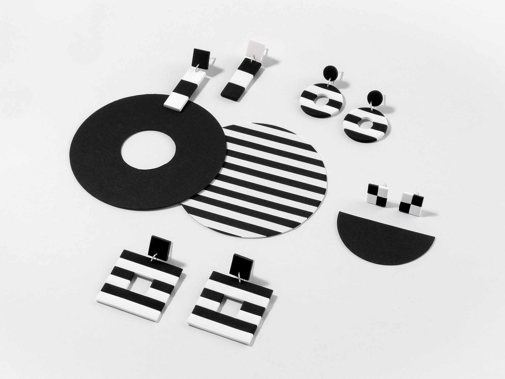 Handmade Black & White earrings – modern, geometric dangles and studs with iconic stripes and checks, featuring 925 sterling silver findings, on white background.