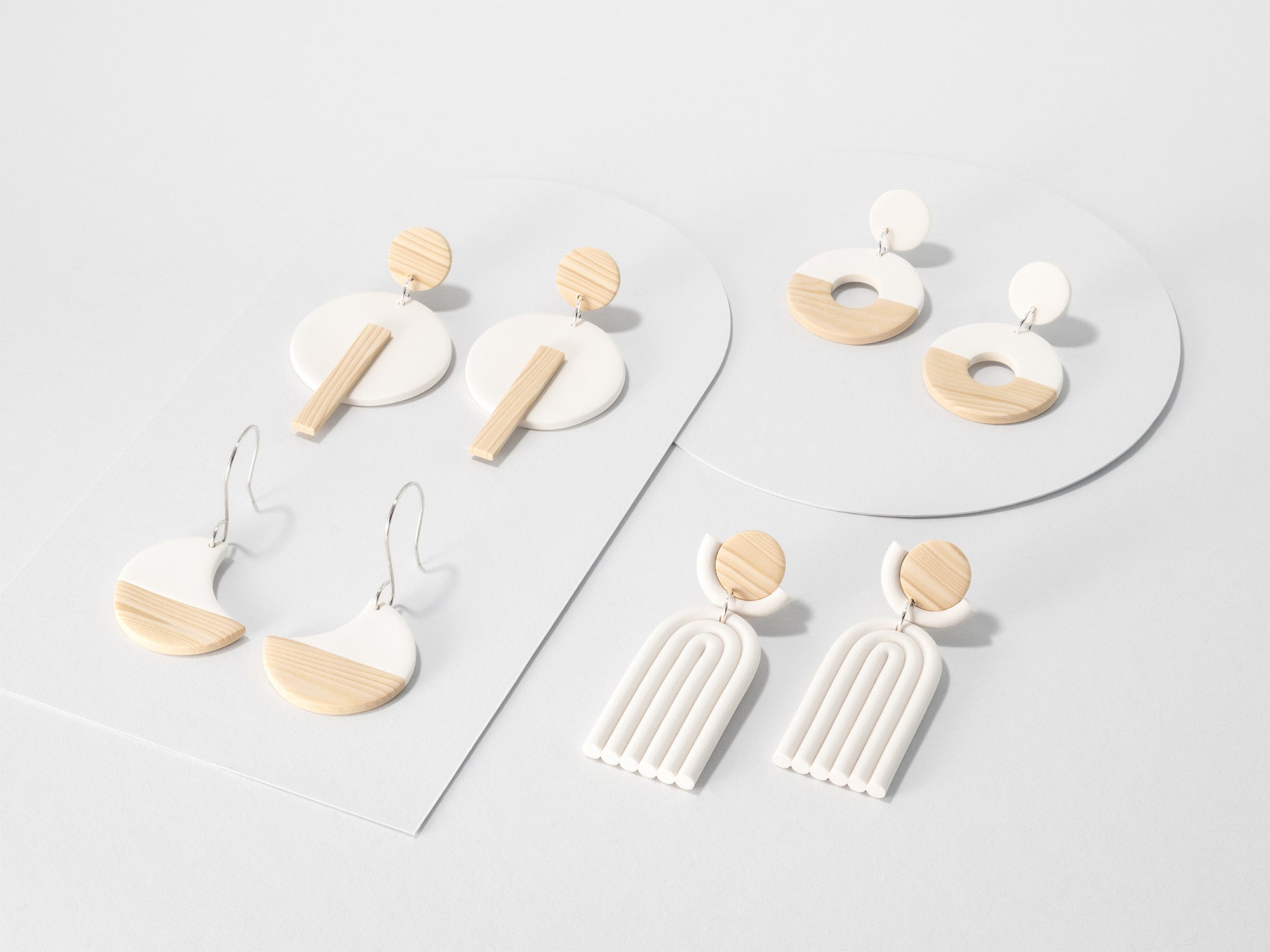 White and woodgrain Kyoto earring pairs – minimalist dangle earrings with 925 sterling silver on light grey background. Geometric, japandi style.