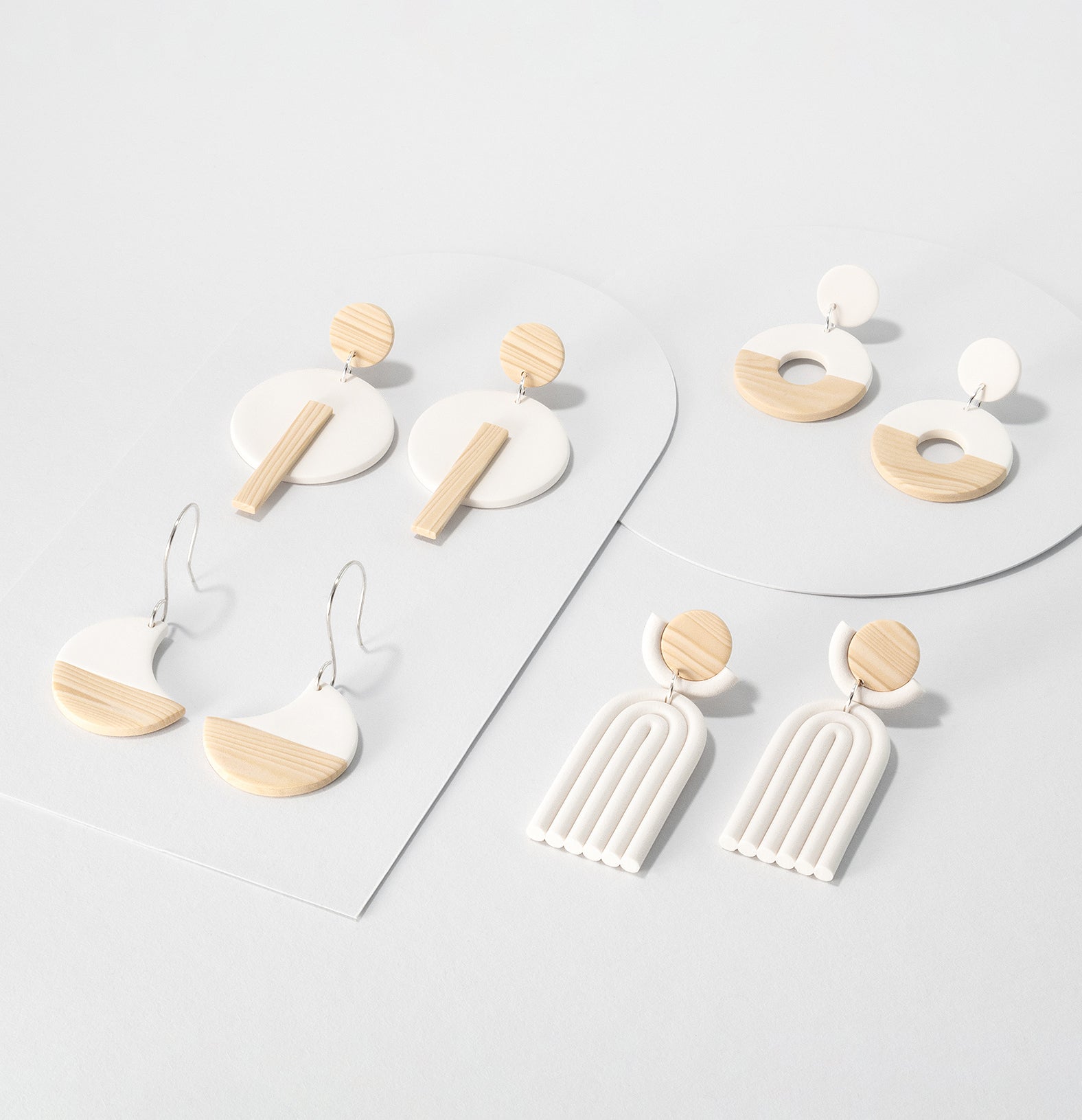 White and woodgrain Kyoto earring pairs – minimalist dangle earrings with 925 sterling silver on light grey background. Geometric, japandi style.